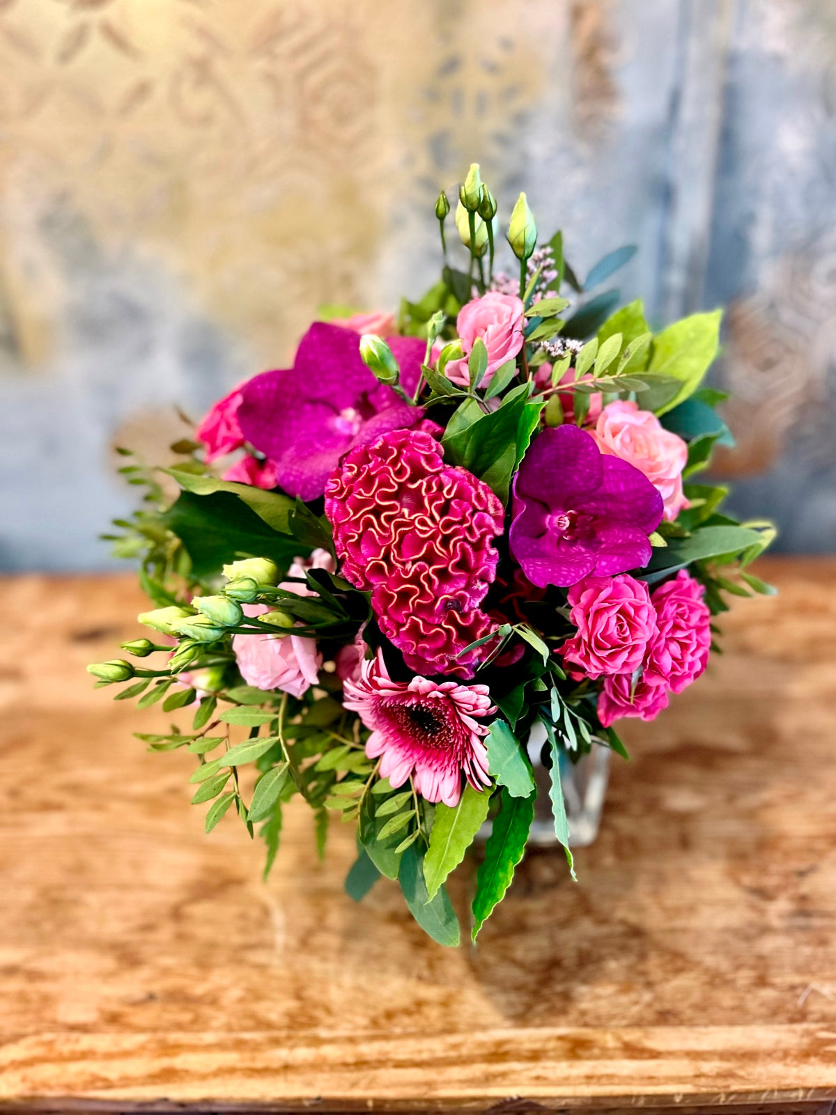 A pretty flower arrangement in shades of pinks in cube vase