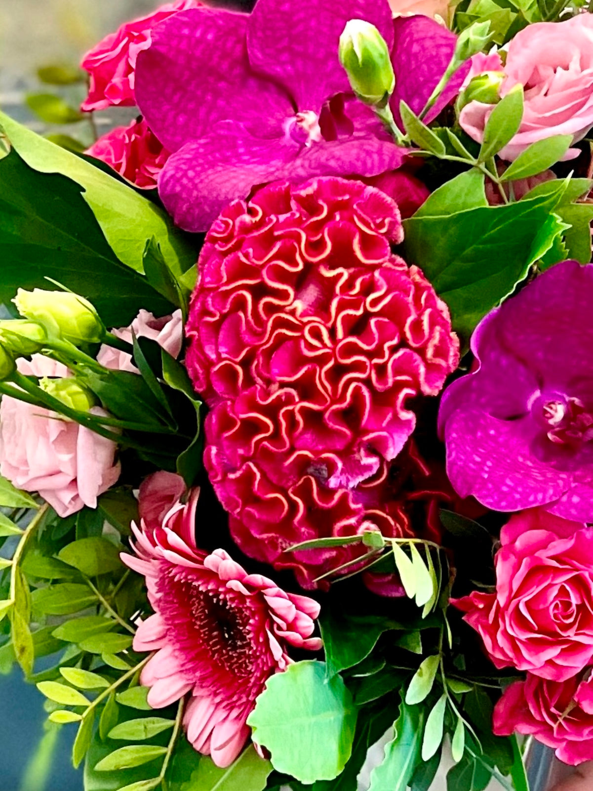 A pretty flower arrangement in shades of pinks in cube vase zoomed in image