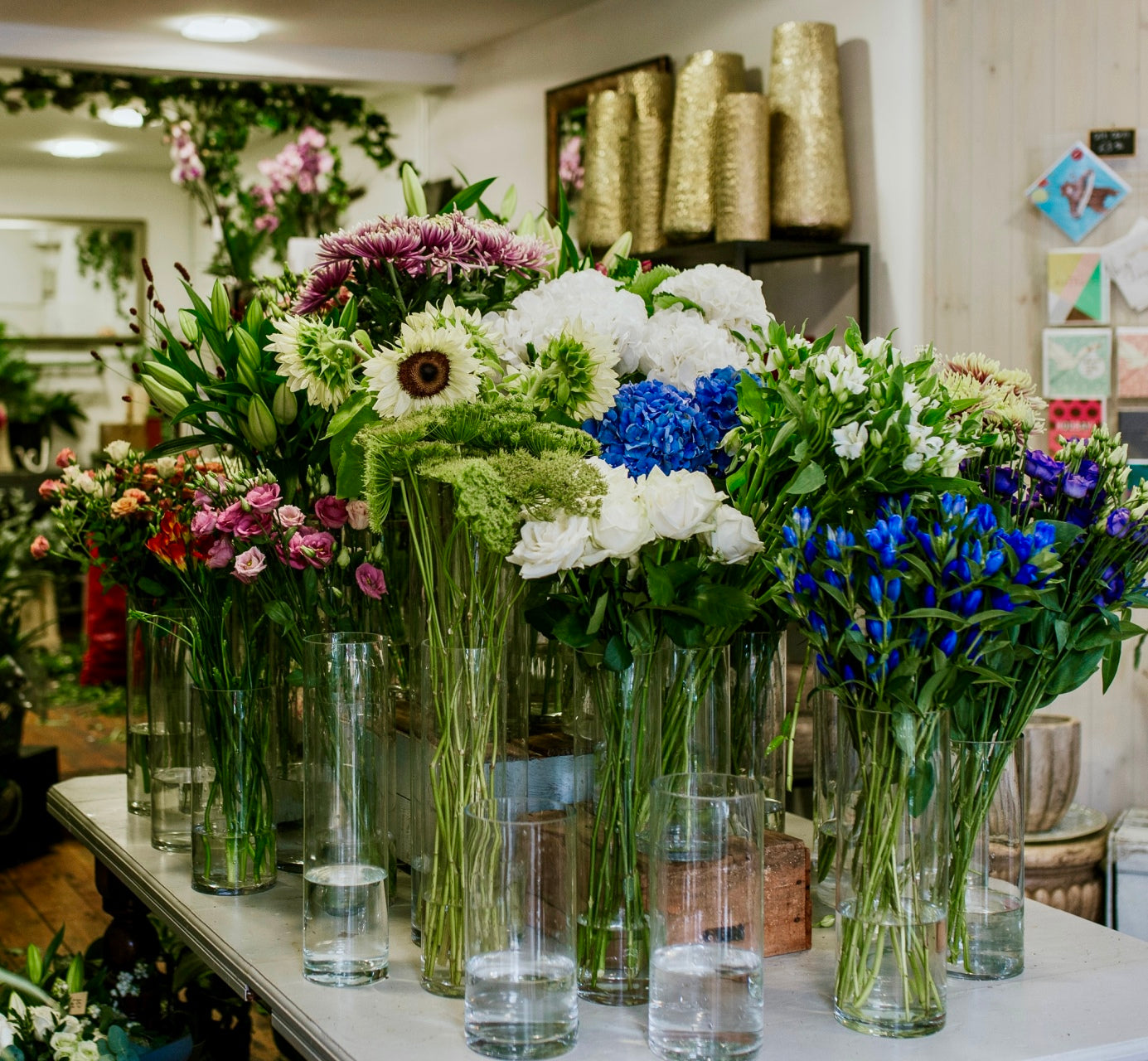Tall flowers in vases by Blooming Amazing Flower Company