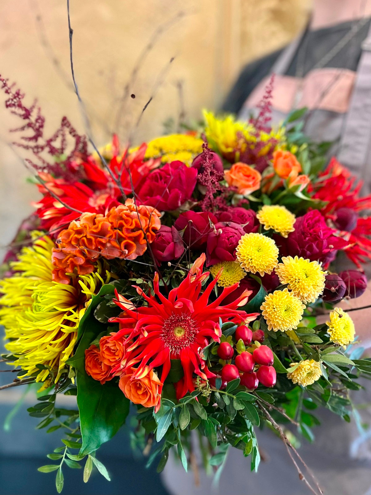 A hand tied flower bouquet in vivid Autumnal colours