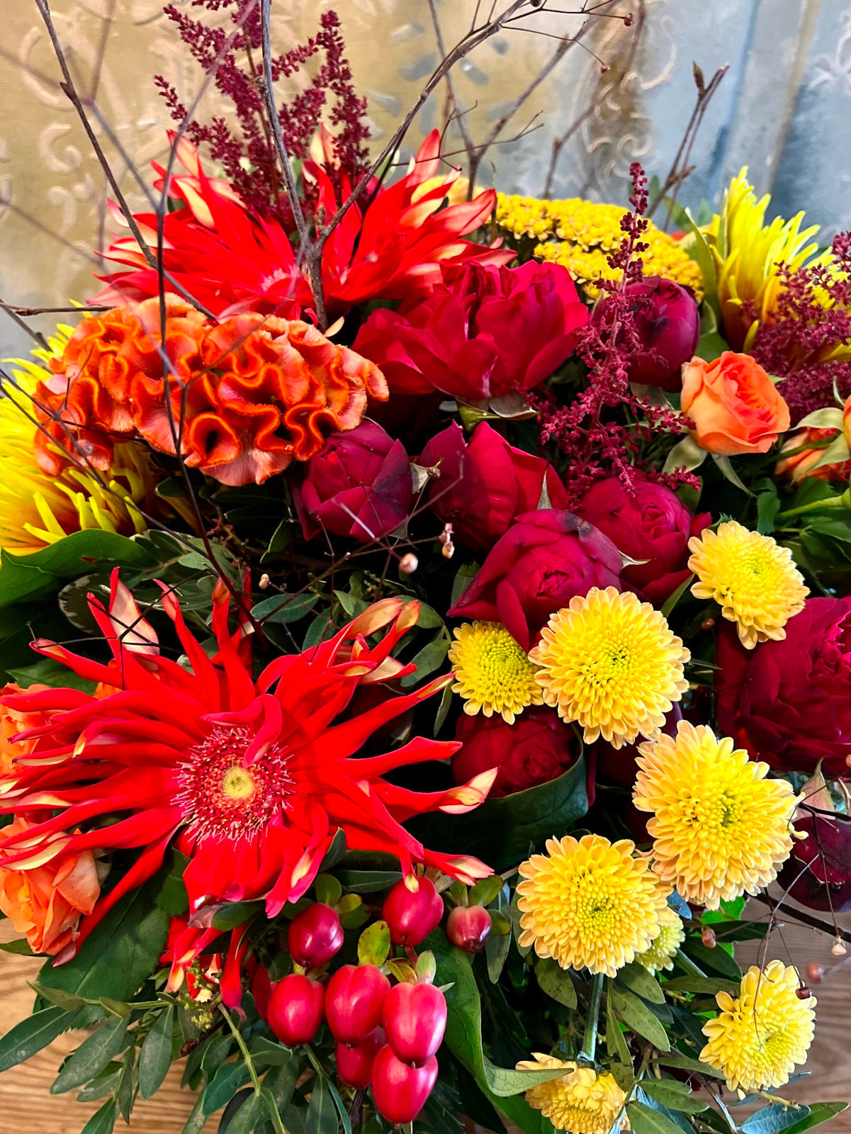 A hand tied flower bouquet in vivid Autumnal colours