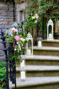 Decorated steps to church using flowers and hurricane lamps 