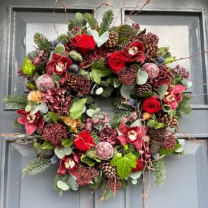 A Christmas door wreath in festive reds hand made by our florists in Ranelagh and ready for delivery in Dublin
