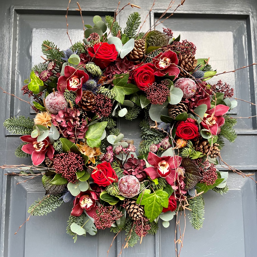A Christmas door wreath in festive reds hand made by our florists in Ranelagh and ready for delivery in Dublin