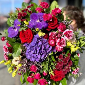 A large luxury bouquet of mixed seasonal flowers and foliage in tones of reds and purples. The hand-tied bouquet is designed in Ranelagh and available to order to collect and for delivery anywhere in Dublin city and county'
