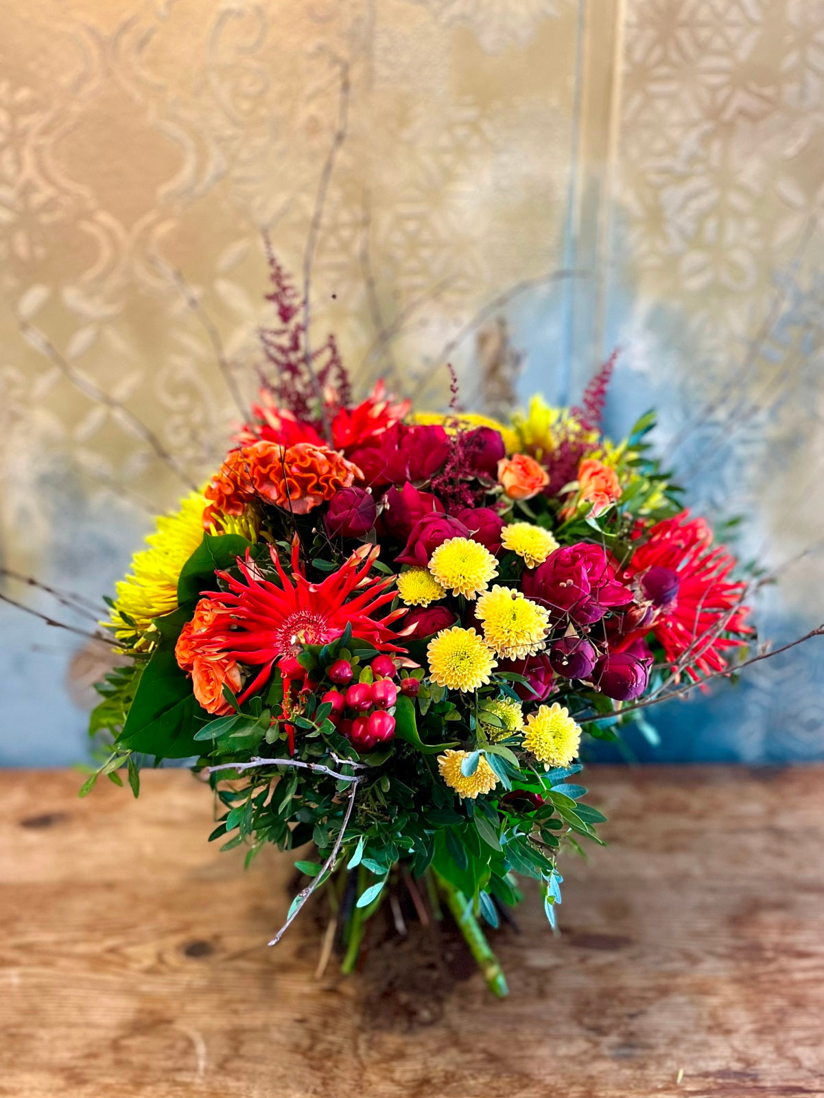 A hand tied flower bouquet in vivid Autumnal colours